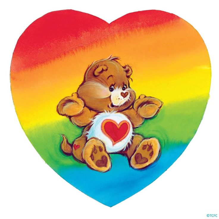 a brown teddy bear sitting on top of a rainbow colored heart