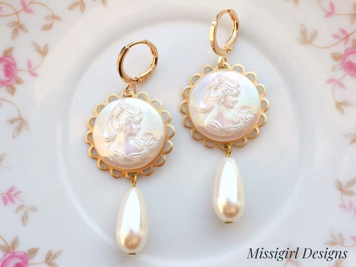 These beautiful cameo earrings were created with ornate brass settings adorned with white pearlescent Cameo cabochons and vintage teardrop pearls. These earrings hang beautifully from gold plated lever back ear wires and measure 2 1/4 inches in length and 7/8 inches in width. ~All of my listings are handmade with love and ready to ship and will arrive to you in a gift box with bow for easy gift giving~ Elegant Round Cameo Earrings, Victorian Pearl Earrings For Pierced Ears, Elegant Cameo Clip-on Earrings Gift, Elegant Cameo Dangle Earrings, Gold Cameo Earrings For Wedding, Elegant Cameo Earrings For Wedding, Victorian Dangle Pearl Earrings, Cameo Drop Earrings For Wedding, Antique Pearl Drop Earrings As Gift