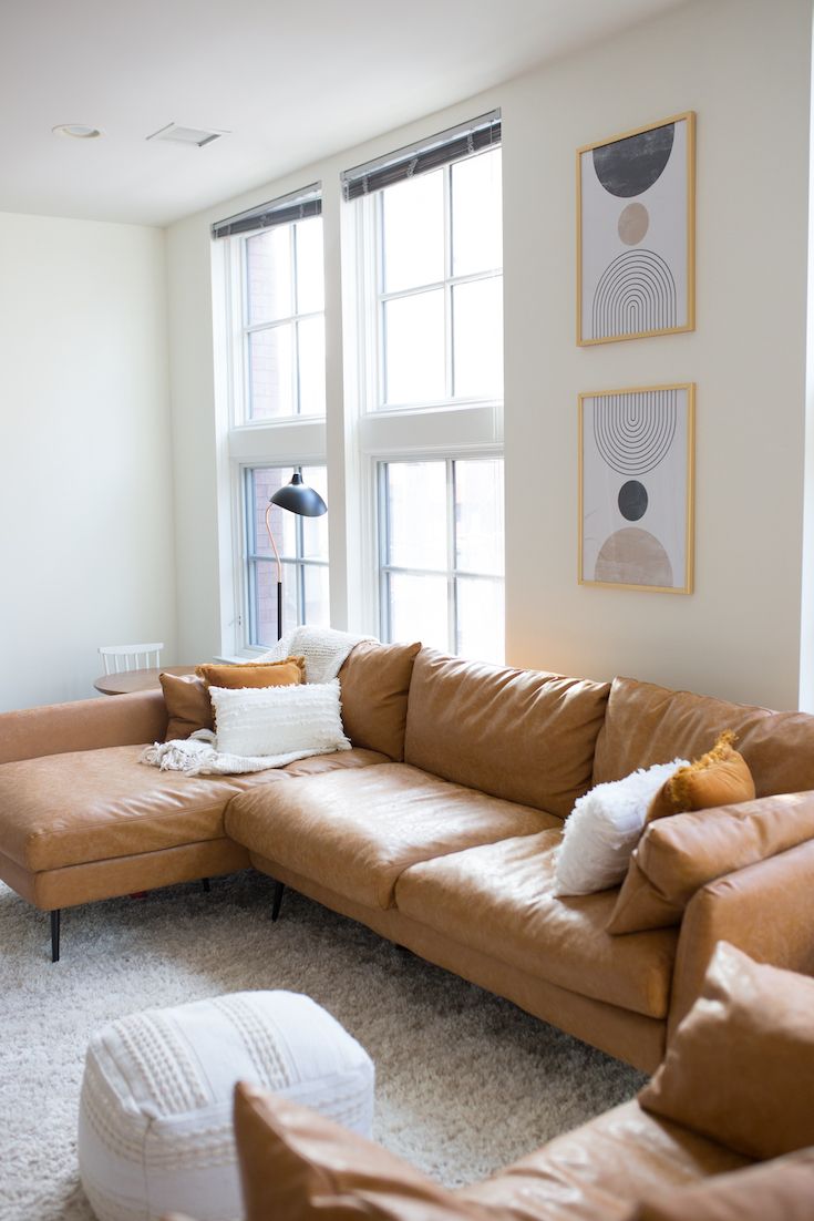 a living room filled with lots of brown furniture