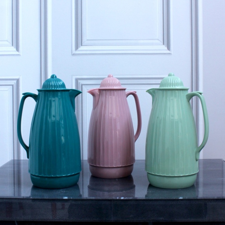 three different colored vases sitting on top of a table