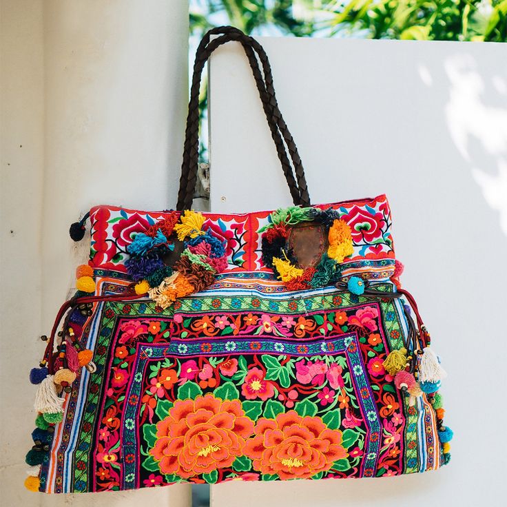 "This charming tote bag for lazy days at the beach and wandering around. It is made with an amazing piece of fabric woven by the HMONG hill tribes of Lanna Region (Northern Thailand). It features cotton lining, leather straps, a zipper closure and adorned with colorful hairs, pom poms. This bag will enhance your appearance. We buy materials from Hmong market and we design and sew by hand. Some of the bags we modify to improve the product. The Hmong tribes live in the North of Thailand and have o Travel Shoulder Bag With Multicolor Embroidery, Bohemian Shoulder Bag With Tassels For Beach Season, Floral Embroidered Summer Vacation Bags, Bohemian Shoulder Bag For Beach Travel, Floral Embroidered Bags For Summer Vacation, Bohemian Shoulder Bag For Beach Season Travel, Summer Vacation Bags With Floral Embroidery, Multicolor Tassel Beach Bag For Everyday, Colorful Bohemian Tote Shoulder Bag