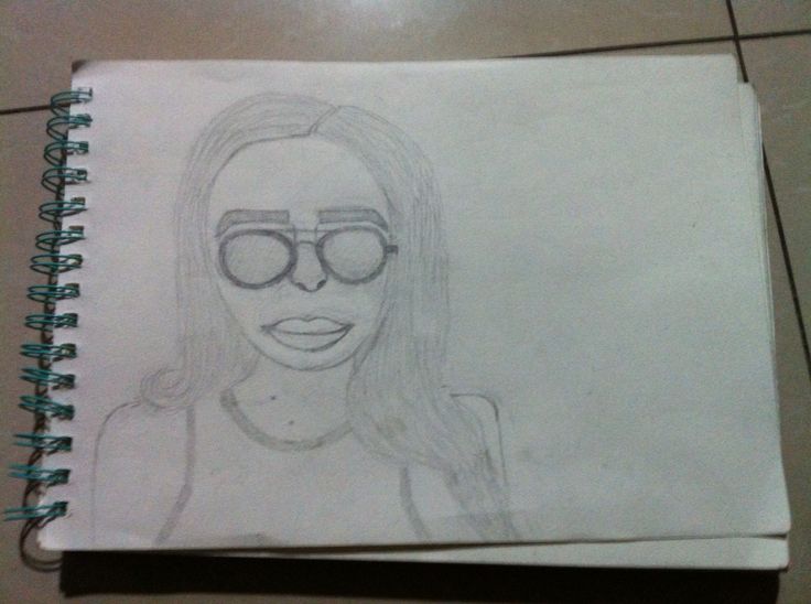 a drawing of a woman with glasses on top of a paper sheet that is laying on the floor