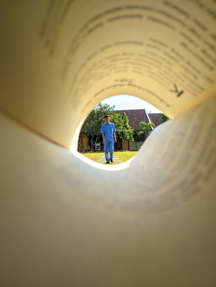 an open book with a man standing in the middle of it, looking at something