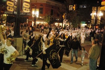 a group of people that are standing in the street with musical instruments and marching gear