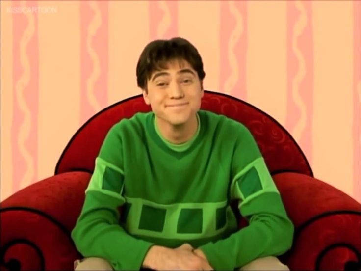 a young man sitting on top of a red chair