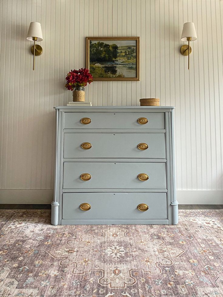 a blue dresser with gold handles in a room