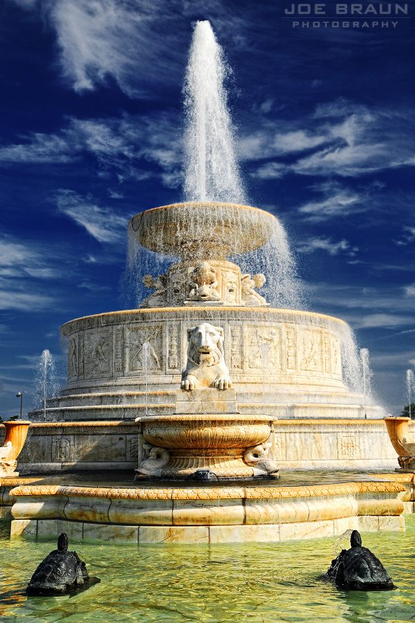 the fountain is surrounded by two large rocks and has water spouting from it