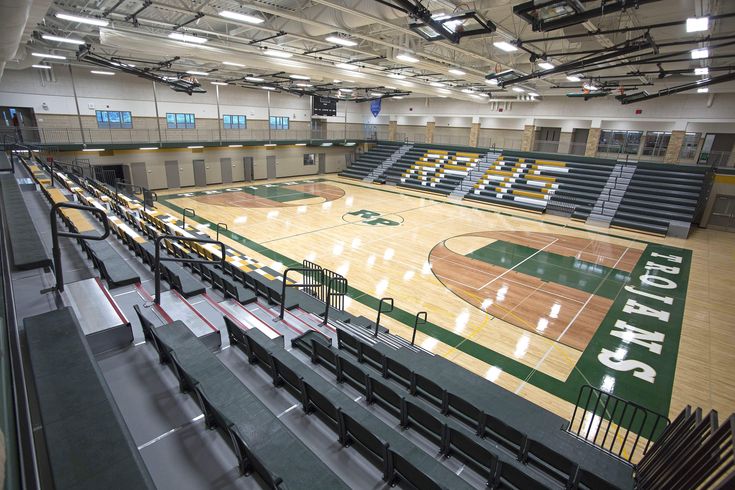 an empty basketball court with benches in the middle