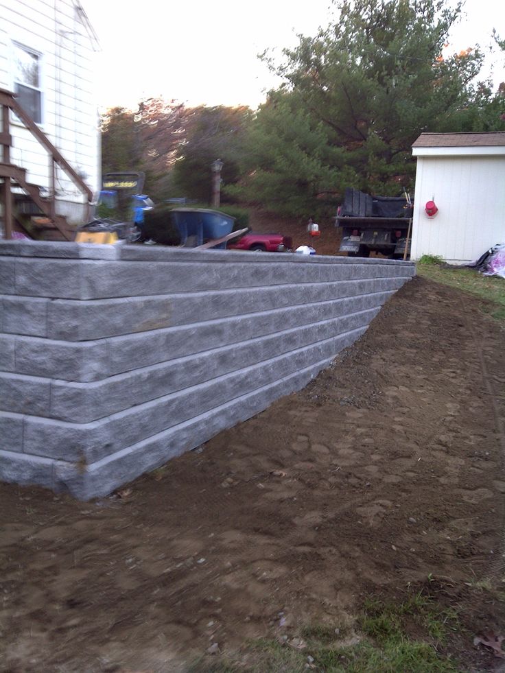 a concrete block retaining wall in front of a house