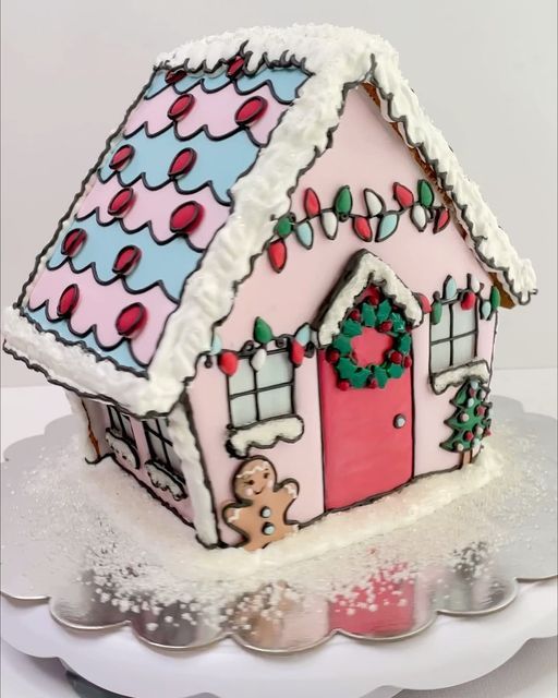 a decorated gingerbread house on top of a cake plate