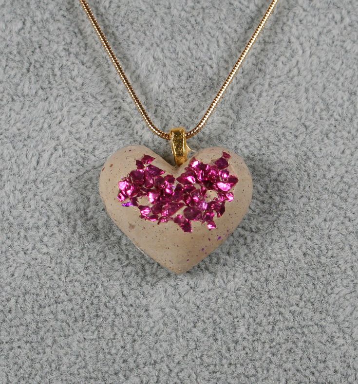 "Gold concrete heart necklace with embedded pink glass.  Heart measures .75\" x 1\". Chain options:  18\" or 20\" silver or gold plated 1.2mm snake chain. Makes a wonderful gift for a bride, bridesmaids, Valentine's Day, Mother's Day, anniversary, birthday... Due to the nature of concrete my pieces may contain small air bubbles and variations in color. Do not submerge in water.  If necessary, it may be cleaned with a damp cloth." Valentine's Day Gift Snake Chain Necklace, Snake Chain Heart Necklace For Gifts, Snake Chain Jewelry For Valentine's Day Gift, Valentine's Day Gift Snake Chain Jewelry, Pink Heart Beads Necklace For Gift, Heart-shaped Pink Jewelry For Mom, Pink Double Heart Necklace For Gift, Pink Double Heart Necklace As Gift, Pink Double Heart Necklace Gift