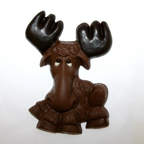 a chocolate moose with antlers on it's head is sitting in front of a white wall