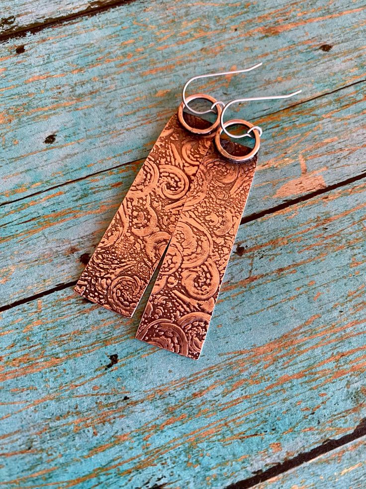 Rustic Hammered Copper Earrings|Handmade Copper Earrings|Antiqued Texturized Artisan Earrings|Boho, Hippie Dangle Earrings Lovely and lightweight bare copper rustic dangle earrings (pics 1-5), hand sawn, texturized, polished and oxidized. Ear wires made of pure commercial grade A hypo-allergenic Titanium, 20 gauge, excellent for sensitive ears. Length is approximately 2  1/4 " (58 mm) and width is slightly over  1/2 " (14 mm) at the widest point. Antiqued, hand-polished for warm aged look and se Handmade Artistic Copper Earrings, Artistic Handmade Copper Earrings, Bronze Bohemian Earrings With Ear Wire, Bohemian Bronze Earrings With Ear Wire, Brown Rectangular Bohemian Earrings, Bohemian Brown Rectangular Earrings, Bohemian Copper Plug Earrings Nickel Free, Handmade Copper Bohemian Plug Earrings, Handmade Bohemian Copper Plug Earrings