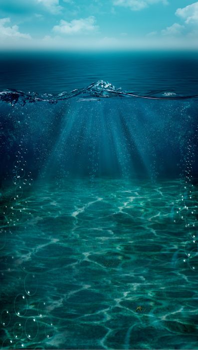 an underwater view of the ocean with blue sky and sunbeams in the background