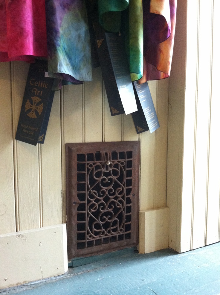 colorful towels hang on the wall next to an iron grate