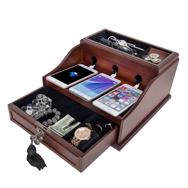 an open wooden jewelry box with various items in it, including cell phone and watch