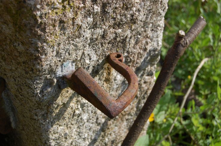 an old rusted padlock attached to a rock