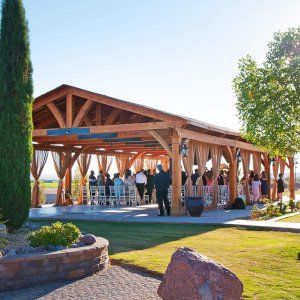 a group of people standing under a wooden structure