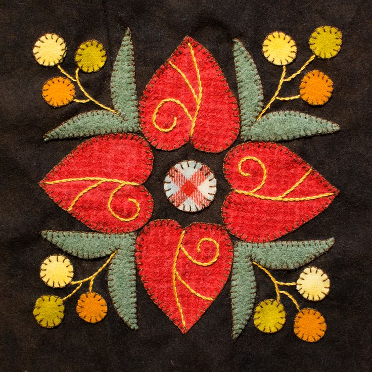 an embroidered design on black fabric with yellow and red flowers