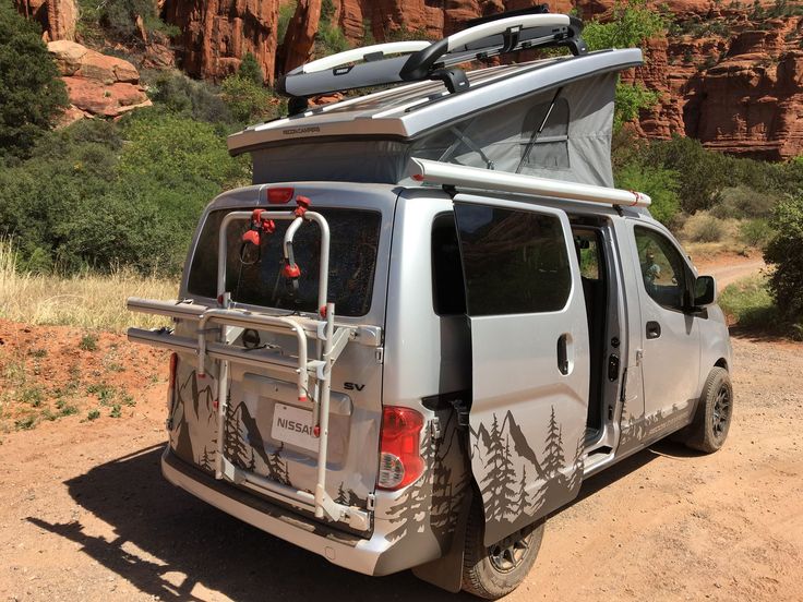 the van is parked on the side of the road with its roof up and it's cargo compartment open