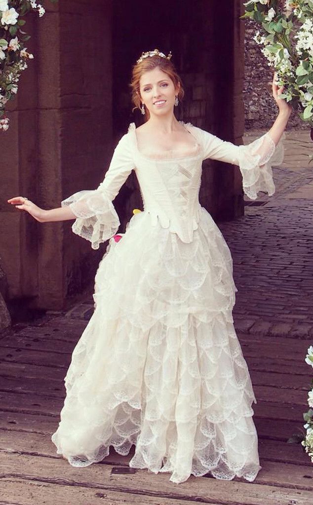 a woman in a white dress is posing for the camera with her arms spread out