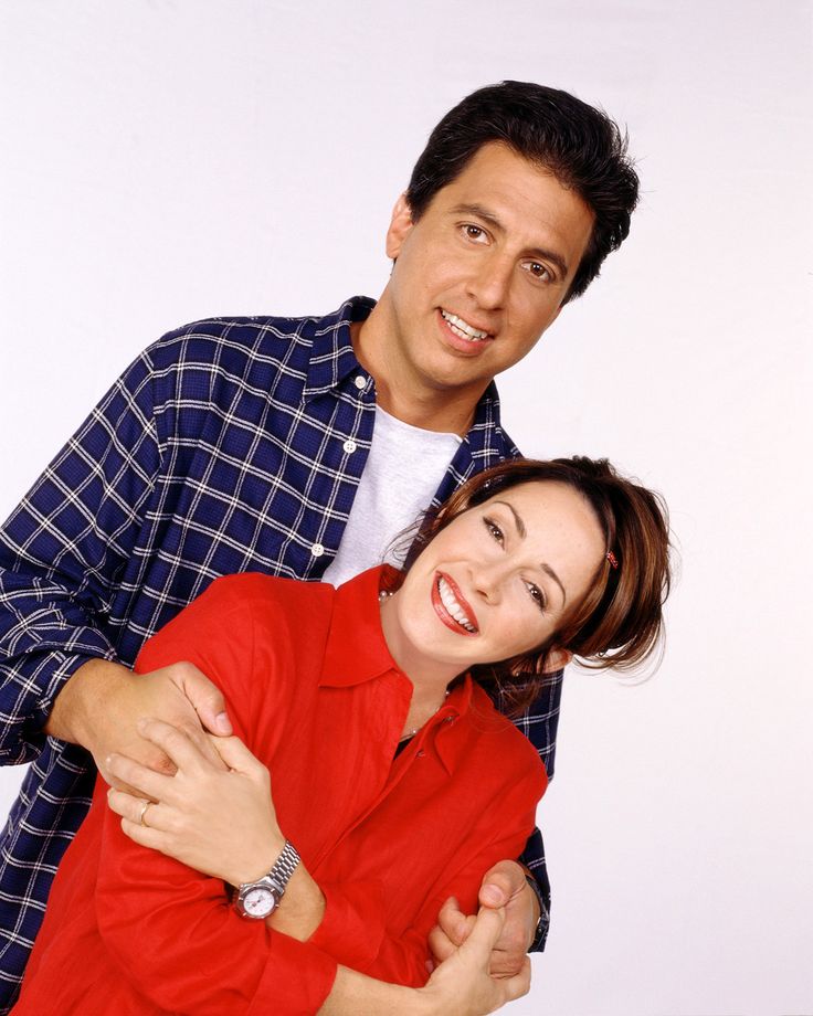 a man and woman hugging each other in front of a white background