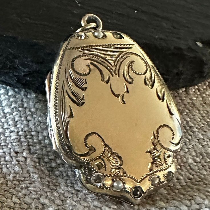 "A Vintage fancy shield shaped Lockewt Gold-filled, paste jewels, lovely hand end engraved design.  Condition is good for its Age any slight wear or age to stones commensurate with age-photos show the details.  size 1 1/8\" by 7/8\", closes tight, hinge is good, inside clean.  If you love vintage lockets this is Treasure from the past." Luxury Vintage Keepsake Necklaces, Heirloom Etched Jewelry For Wedding, Heirloom Etched Wedding Jewelry, Ornate Oval Antique Gold Jewelry, Ornate Oval Jewelry In Antique Gold, Formal Etched Bronze Jewelry, Vintage Engraved White Gold Necklace, Antique Gold Engraved Brass Jewelry, Victorian Silver Necklace With Antique Finish