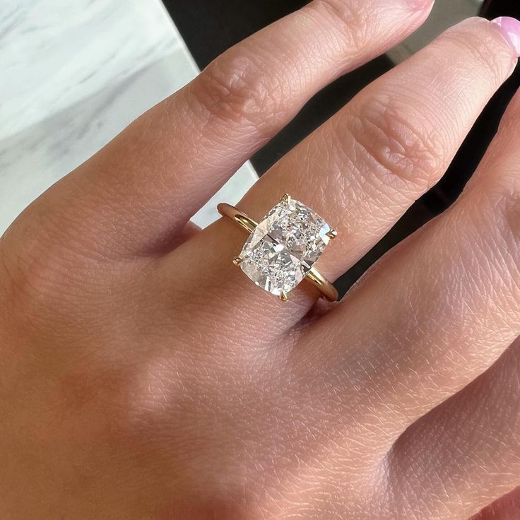 a woman's hand with a diamond ring on it