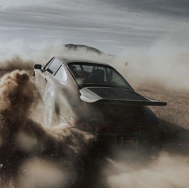 a car is driving through the sand with it's wheels in the air