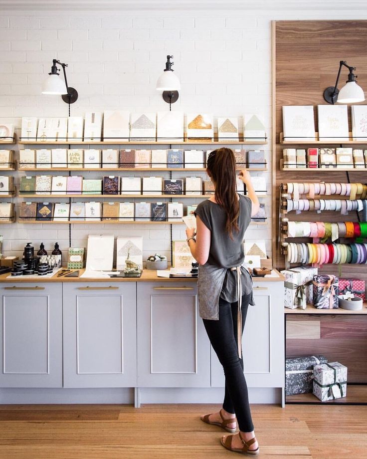 a woman standing in front of a counter with lots of crafting supplies on it