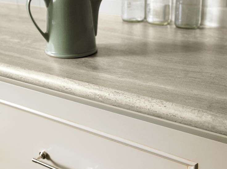 a green coffee pot sitting on top of a counter next to jars and drawers in a kitchen