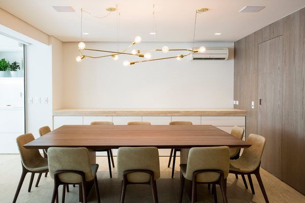 a large wooden table surrounded by chairs in a room with white walls and wood flooring