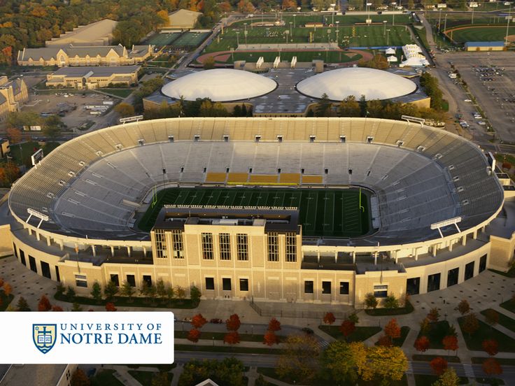 an aerial view of a football stadium with trees in the background