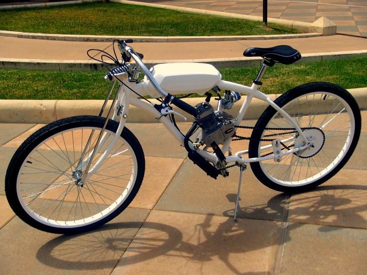 a white and black bike parked on the sidewalk