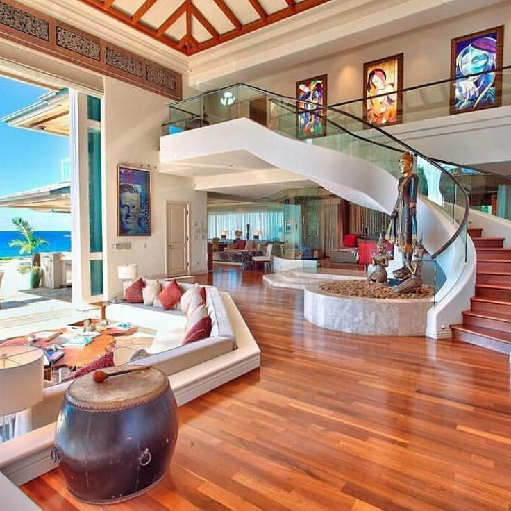 a living room filled with furniture and a spiral staircase leading up to the top floor