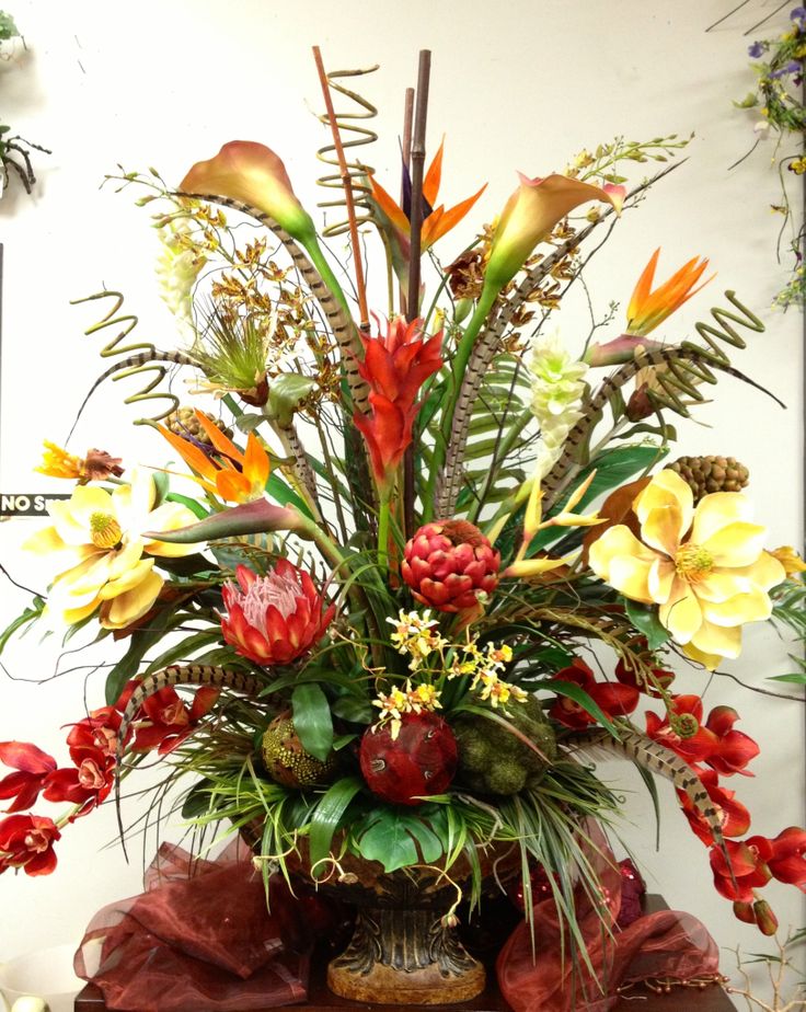 a vase filled with lots of flowers on top of a table