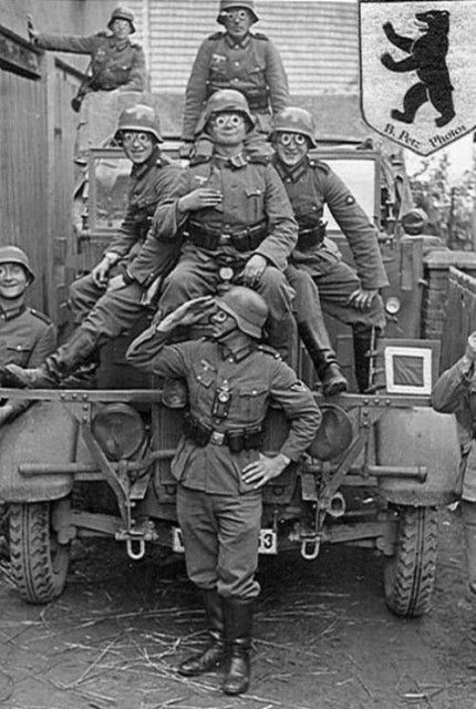 an old black and white photo of men in uniforms on the back of a truck