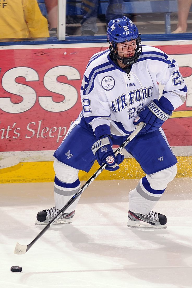 a hockey player in blue and white uniform on the ice