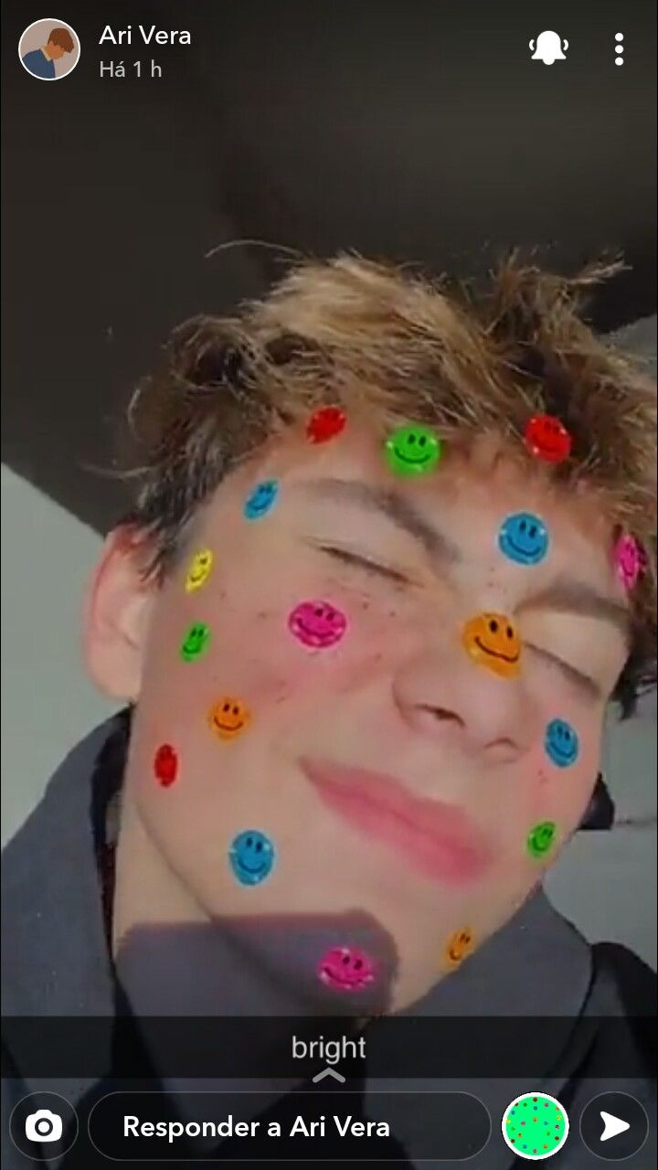 a young man with his eyes covered in smiley face stickers and looking at the camera