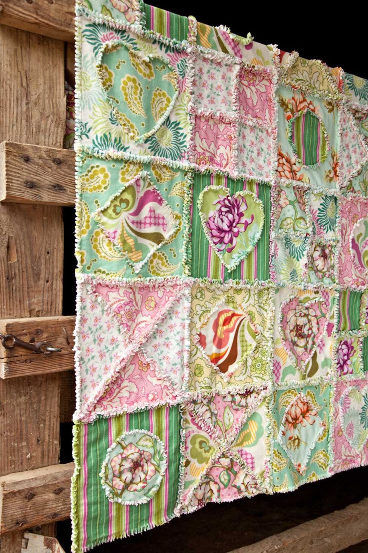 a quilt hanging on the side of a wooden structure