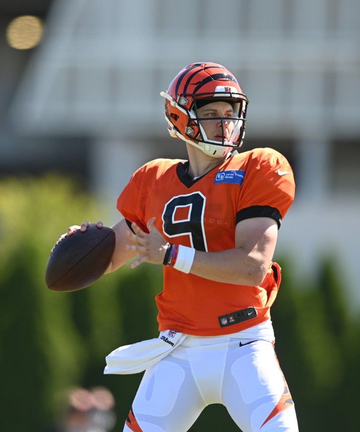 a close up of a football player holding a ball and wearing an orange jersey with the number 9 on it