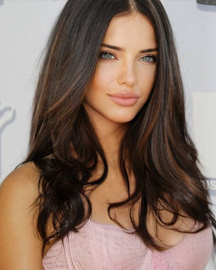 a close up of a person with long hair and blue eyes wearing a pink dress