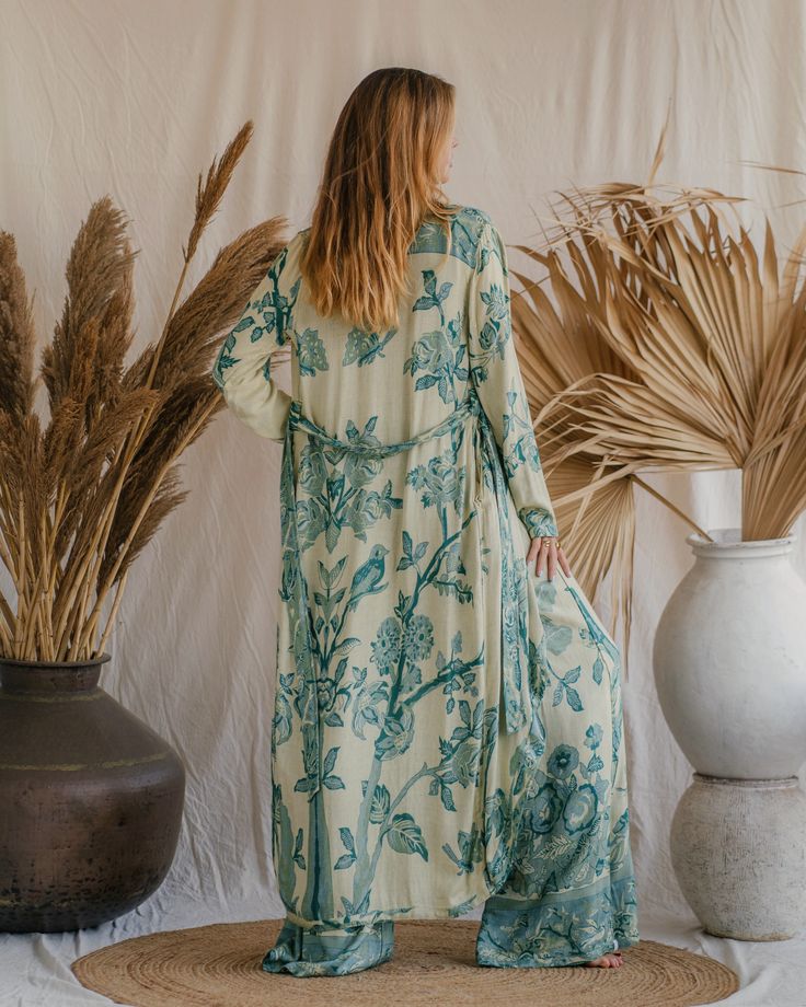 Our Aphrodite Original Kaftan, made from soft viscose double gauze fabric, offers a luxurious feel and an ethereal appearance. Designed to enhance your presence in any setting, its flowing silhouette and lightweight, breathable fabric ensure a graceful and comfortable fit. Ideal for lounging by the pool or attending special events, this piece is perfect for making a statement. Its versatile design provides multiple styling options, making it an indispensable addition to your wardrobe. Celebrate your divine beauty and radiate grace with our reversible Original Kaftan Flowy Maxi Kimono For Loungewear, Flowy Maxi Length Kimono For Loungewear, Bohemian Silk Flowy Kimono, Bohemian Silk Kimono, Bohemian Wrap Robe With Flowy Fit, Flowy Bohemian Silk Kimono, Bohemian Flowy Wrap Robe, Green Bohemian Wrap Maxi Dress, Bohemian Long Sleeve Silk Maxi Dress