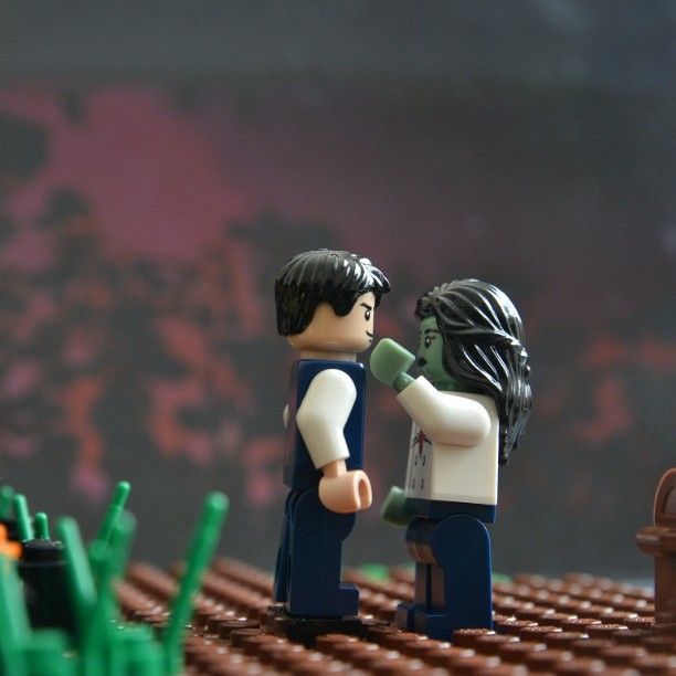 two lego people standing next to each other