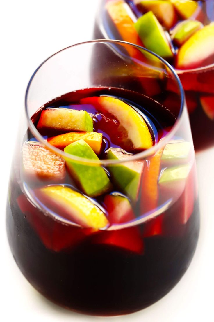 two glasses filled with liquid and fruit slices