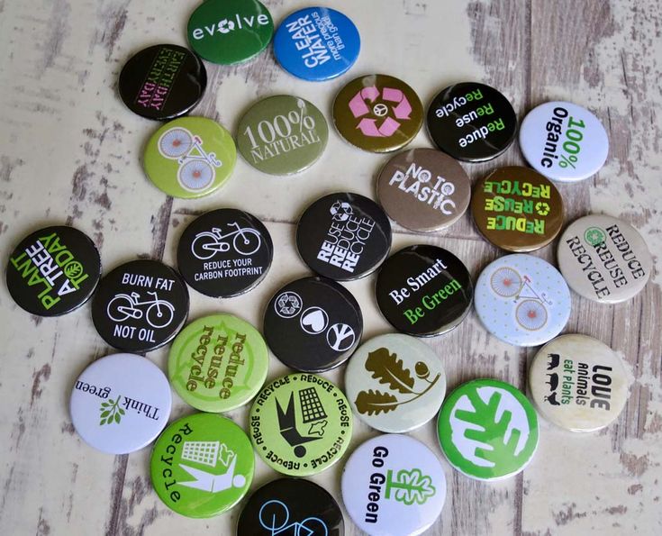 a bunch of buttons that are sitting on the floor with words written on them, all in different colors and sizes