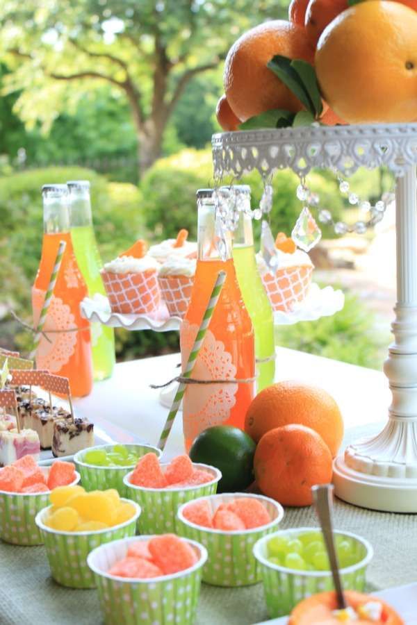 a table topped with cups filled with oranges and watermelon juice next to fruit