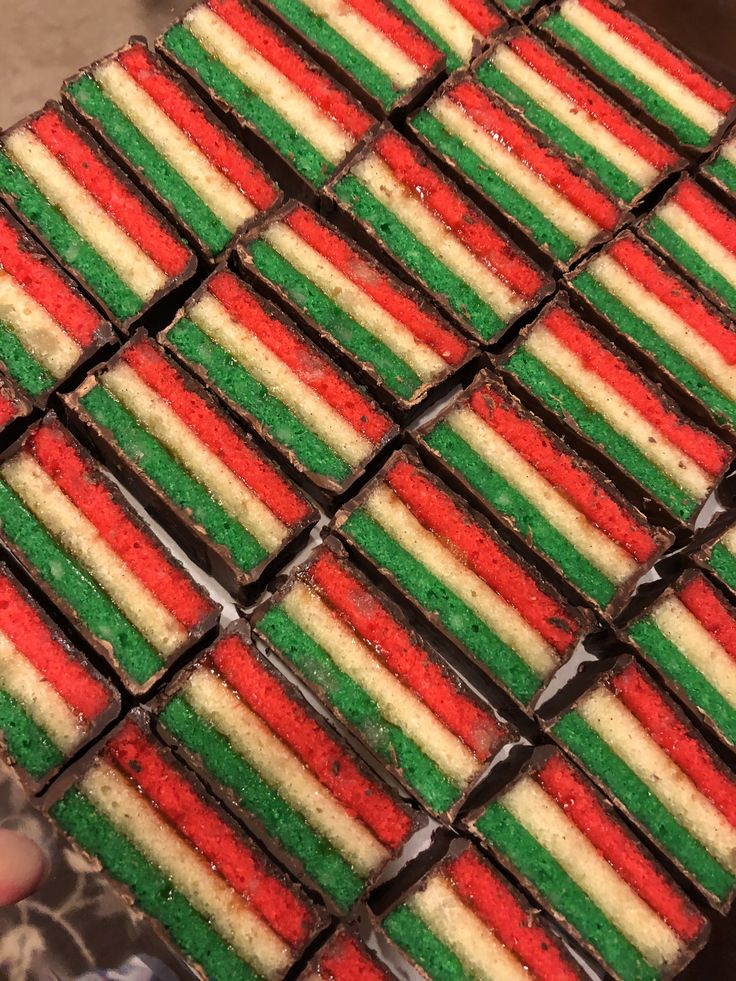 there are many different colored cookies on the trays that have been cut into squares