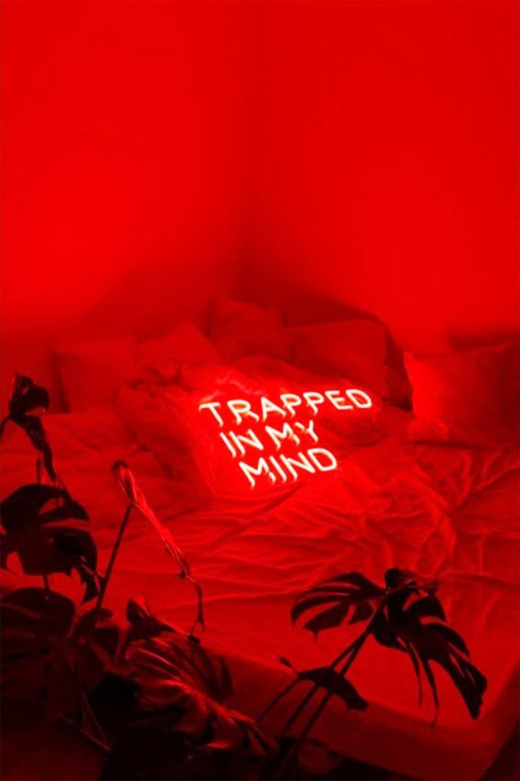 a bed with a neon sign that says trapped in my mind on it's side