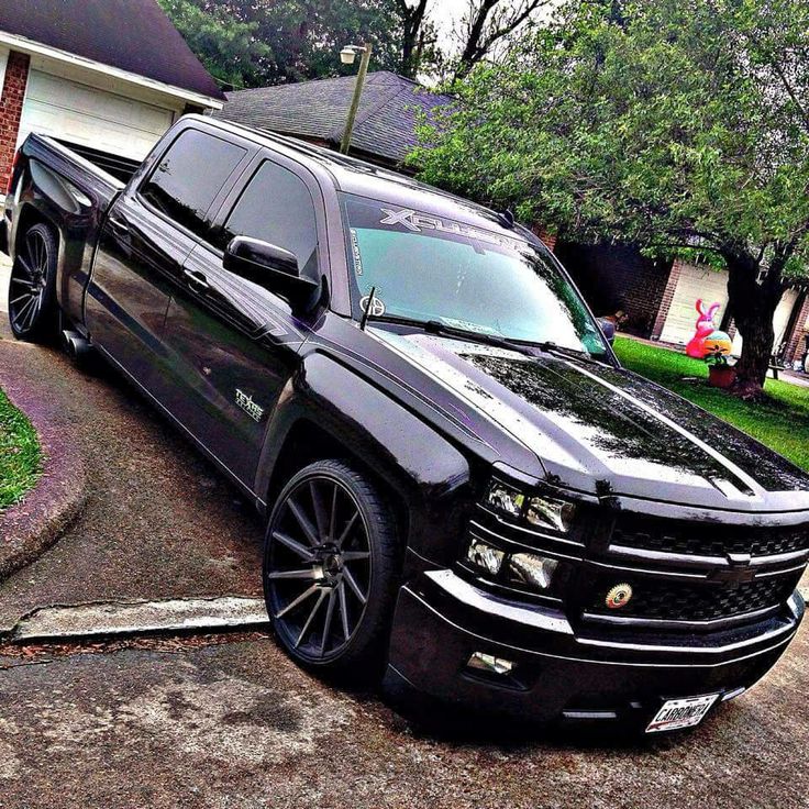 a black truck parked in front of a house